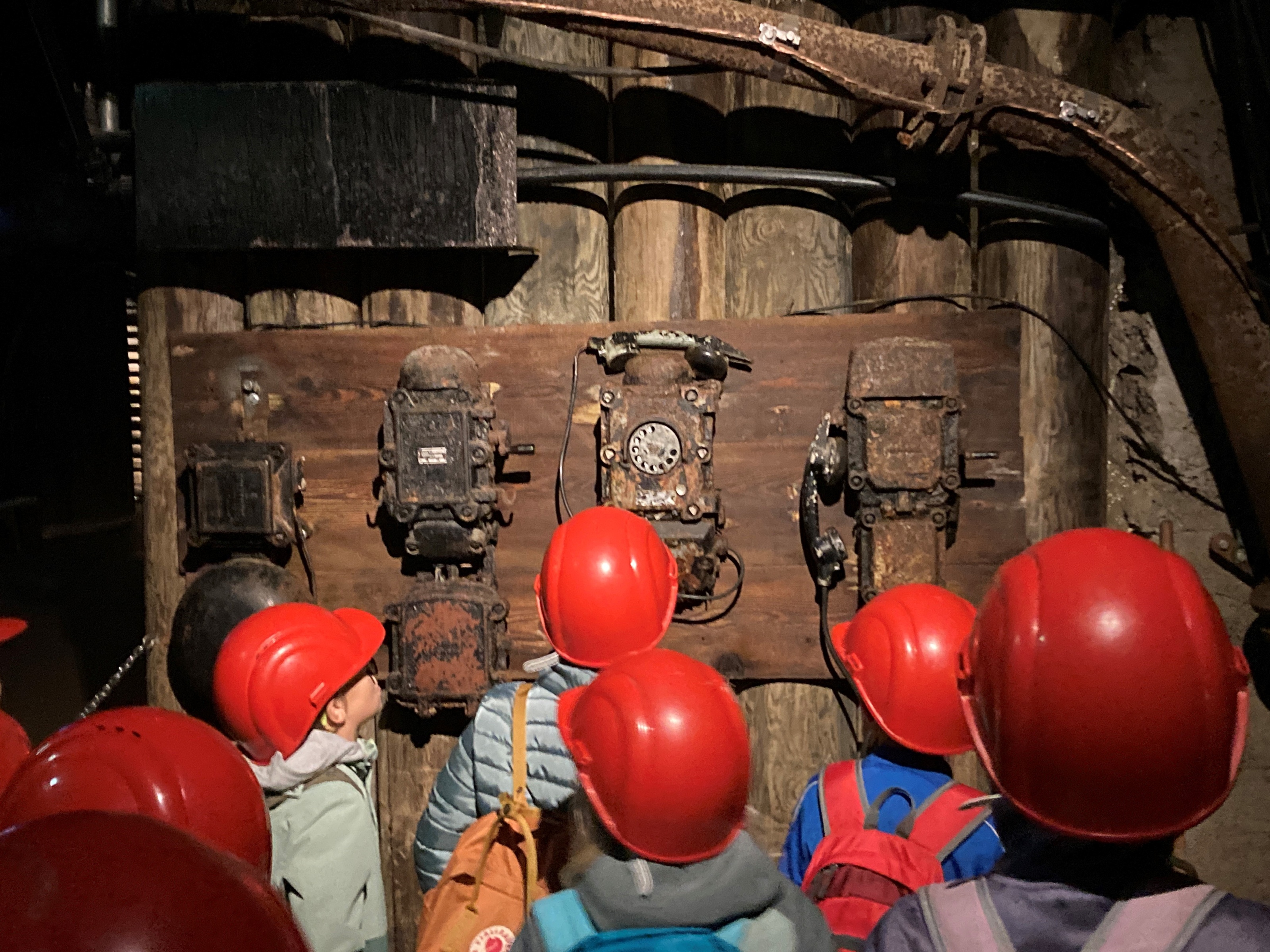 Kinder mit Schutzhelmen von hinten im Schaubergwerk Erzberg.